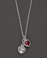 A twin heart necklace in crystal and red corundum framed in sterling silver. Designed by Judith Ripka. A twin heart necklace in crystal and red corundum framed in sterling silver. Designed by Judith Ripka.