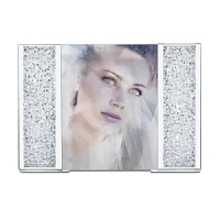 Thousands of shimmering crystals glitter in the columns of this festive picture frame with silver-tone metal details. A perfect way to show off your special moments in style, the frame can display standard portrait photos measuring 4 x 3.