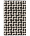 Houndstooth hip. Add some contemporary chic to your home with Surya's Cosmopolitan area rug. Hand-tufted of strong, no-shed polyacrylic in a graphic houndstooth print, this rug is the epitome of urban cool. The pairing of black and ecru offers a sophisticated look that's always in style.