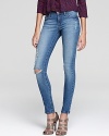 Rock downtown cool in these DL1961 distressed and torn faded jeans and add edge to your weekends.