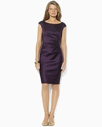 A chic boat neckline lends sophisticated appeal to the dress, tailored from stretch satin and finished with knife pleats at the left waist for a body-contouring fit. A chic boat neckline lends sophisticated appeal to the dress, tailored from stretch satin and finished with knife pleats at the left waist for a body-contouring fit.