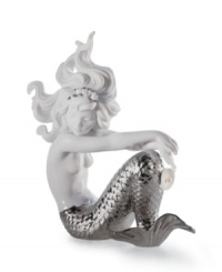 A dramatic, silver mermaid tail makes this unique piece from Lladro truly stunning. Decorated with delicate shell and flower jewelry, the underwater beauty lounges in princess-like majesty at the bottom of the sea. 6.5 x 5.25. A dramatic, silver mermaid tail makes this unique piece from Lladro truly stunning. Decorated with delicate shell and flower jewelry, the underwater beauty lounges in princess-like majesty at the bottom of the sea. 6.5 x 5.25.