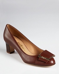 A decorative, architectural buckle adorns the front of Salvatore Ferragamo's Thais pumps, a classic shoe with iconic staying power. A decorative, architectural buckle adorns the front of Salvatore Ferragamo's Thais pumps, a classic shoe with iconic staying power.