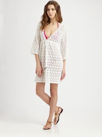 A gorgeous crochet coverup with a feminine self-tie neckline.Deep v-necklineThree-quarter sleevesSelf-tie frontCord endsElasticized waistCottonDry cleanMade in USA of imported fabric A gorgeous crochet coverup with a feminine self-tie neckline.Deep v-necklineThree-quarter sleevesSelf-tie frontCord endsElasticized waistCottonDry cleanMade in USA of imported fabric