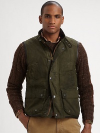 Utility pockets and a rugged oilcloth construction imbue this vest with an authentic look and feel.Full-zip frontSnap button placketStand collarChest slash, waist flap pocketsAbout 27 from shoulder to hemCottonDry cleanImported