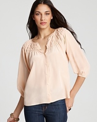 In a pale melon hue, Tucker's essential silk blouse gets a summer-ready update with smocked detailing. In a pale melon hue, Tucker's essential silk blouse gets a summer-ready update with smocked detailing.