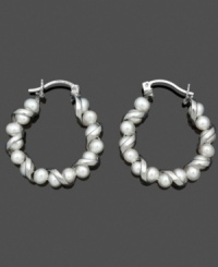 A not-so-traditional pair of hoop earrings. A spiraling sterling silver setting adds a simple twist to shimmery cultured freshwater pearls (4-5 mm). Approximate diameter: 9/10 inch.