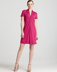 Exercise restrained minimalism with this Calvin Klein tee shirt dress. An elegant knotted neckline finishes a clean silhouette for a versatile closet essential. Exercise restrained minimalism with this Calvin Klein tee shirt dress. An elegant knotted neckline finishes a clean silhouette for a versatile closet essential.