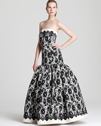 Own the red carpet in this smashing Milly strapless gown, cut with a drop waist and featuring a stunning black lace print. An oversized skirt lined with tiers of tulle flairs out, creating a gorgeous silhouette for high impact on your special occasion. Own the red carpet in this smashing Milly strapless gown, cut with a drop waist and featuring a stunning black lace print. An oversized skirt lined with tiers of tulle flairs out, creating a gorgeous silhouette for high impact on your special occasion.