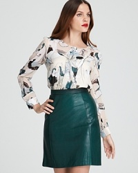 Oversized florals bloom against a sheer DKNY blouse for a sophisticated approach to office chic. Slip the light-as-air style into a pencil skirt for feminine polish.