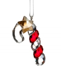 Shiny and sweet, the Swarovksi crystal candy cane ornament features ribbons of holiday red and a dangling gold star. Shiny and sweet, the Swarovksi crystal candy cane ornament features ribbons of holiday red and a dangling gold star.