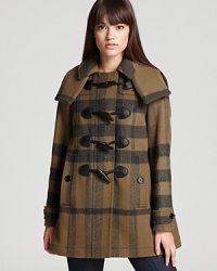 Approach the cold-weather season with chic style sense in this Burberry Brit coat, featuring an oversized check print and rustic toggle closures for a heritage look. Approach the cold-weather season with chic style sense in this Burberry Brit coat, featuring an oversized check print and rustic toggle closures for a heritage look.