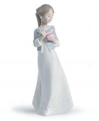 A graceful way of showing you care, this handmade porcelain figurine from Lladro presents a young woman in flowing white with carved detailing upon her dress and sweater wrap. A graceful way of showing you care, this handmade porcelain figurine from Lladro presents a young woman in flowing white with carved detailing upon her dress and sweater wrap.