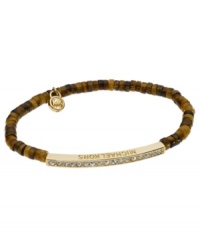 Beaded with a touch of sparkle. Michael Kors' stretch bracelet features semi-precious beaded details in brown hues with a pave glass bar. Bar accent and logo charm crafted in gold tone mixed metal. Bracelet stretches to fit wrist. Approximate diameter: 2-1/4 inches. Approximate width: 1/8 inch.