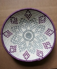 A reminder of Rwanda's past but also its potential, this beautiful hand-woven basket is a symbol of strength, any way you look at it. The geometric pattern, inspired by complex African gemstones, pops with elements of rich purple, slate blue and natural ivory. A reminder of Rwanda's past but also its potential, this beautiful hand-woven basket is a symbol of strength, any way you look at it. The geometric pattern, inspired by complex African gemstones, pops with elements of rich purple, slate blue and natural ivory.